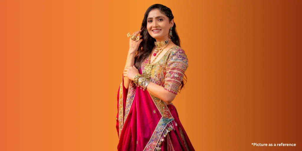 Geeta Rabari is dressed in a traditional Gujarati outfit, adorned with jewelry, and smiles gracefully against an orange gradient background.