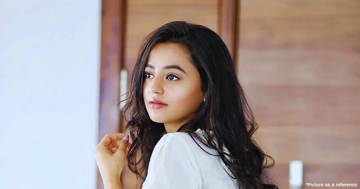 A Gujarati actress, Helly Shah, is giving a beautiful pose with open hair and wearing a white Western dress.