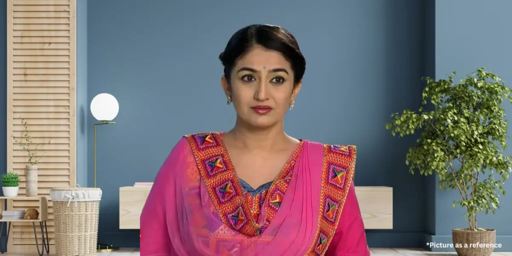 Neha Mehta in a pink traditional outfit with colorful embroidery, looking thoughtful.