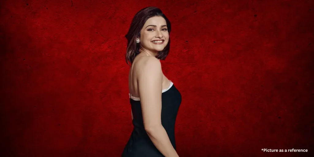 Prachi Desai is in a stylish black dress, smiling confidently against a bold red textured background.