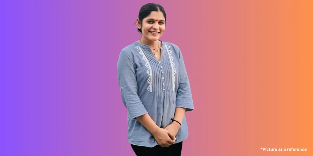 Aarti Sangani looking to the side, wearing an olive green puff-sleeve top.