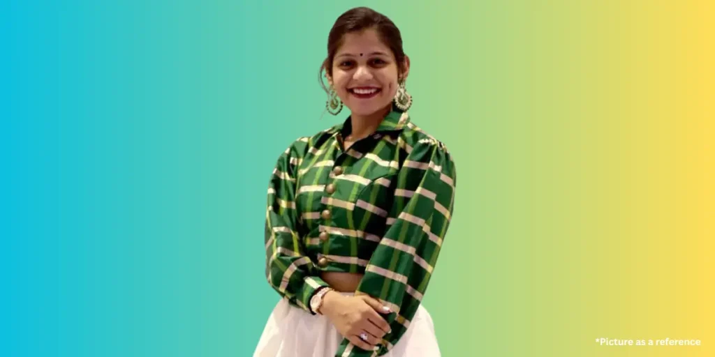 Aarti Sangani wearing a green and gold checkered traditional crop top and white skirt with large earrings.
