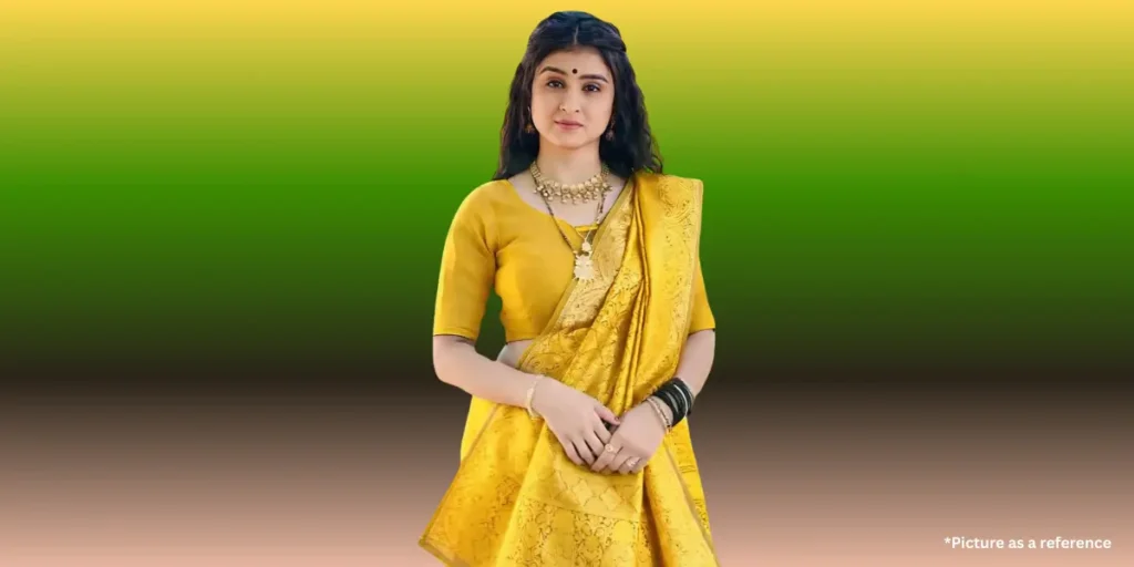 Geet Thakkar is in a traditional yellow silk saree with a matching blouse and heavy gold jewelry.