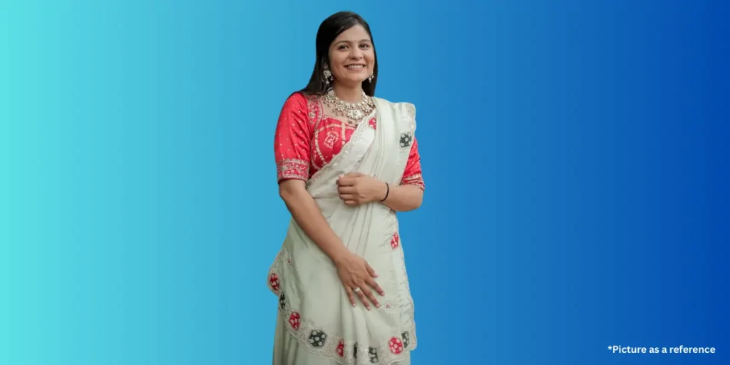 Aarti Sangani dressed in a traditional white and red Gujarati saree with heavy jewelry.