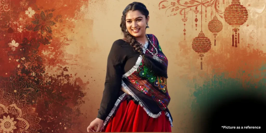 Gujarati celebrity Chaya Thakor wearing a black embroidered choli and red ghagra with traditional folk jewelry.