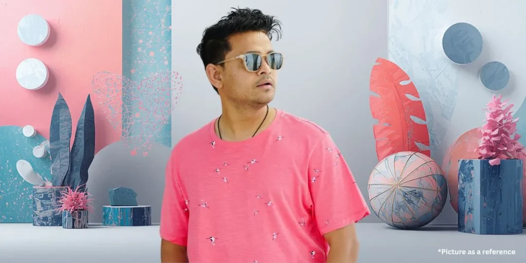 A candid profile shot of Nitin Jani Khajur Bhai wearing a pink bird-print t-shirt and sunglasses.