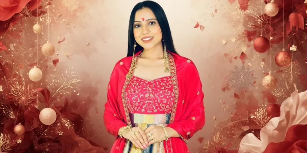 Studio portrait of a smiling Kinjal Rabari in a bright pink silk embroidered suit with a pearl and silver choker.