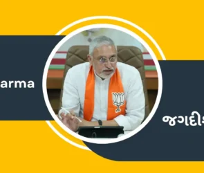 Jagdish Vishwakarma is wearing a BJP saffron scarf and sitting in an office, and his name is written in Gujarati and English.