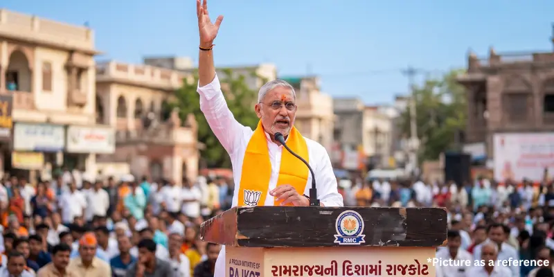 Jagdish Vishwakarma waving to a large outdoor gathering initiative event in Gujarat.