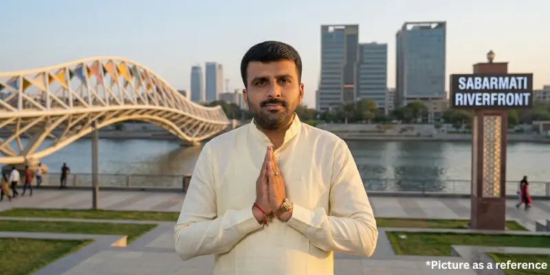 Politician Raju Karpada standing at the Sabarmati Riverfront in Ahmedabad with a namaste gesture.
