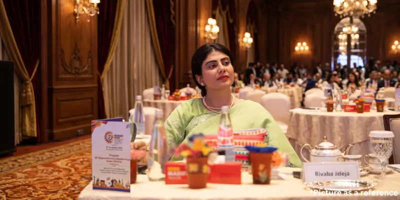 Rivaba Jadeja attending a summit, seated at a table with a nameplate in an elegant hall.