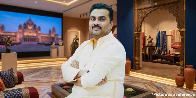 Jignesh Kaviraj posing in a luxury showroom featuring traditional Indian decor, heritage architecture, and ethnic textiles.